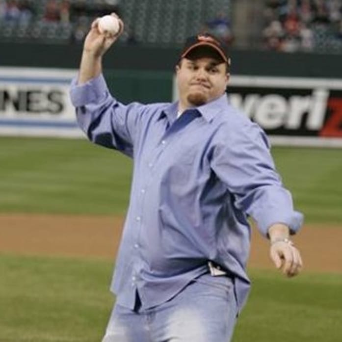 jeremy_01 Man in blue shirt and cap throwing a baseball on a field during a game, captured by Ceemi Agency.